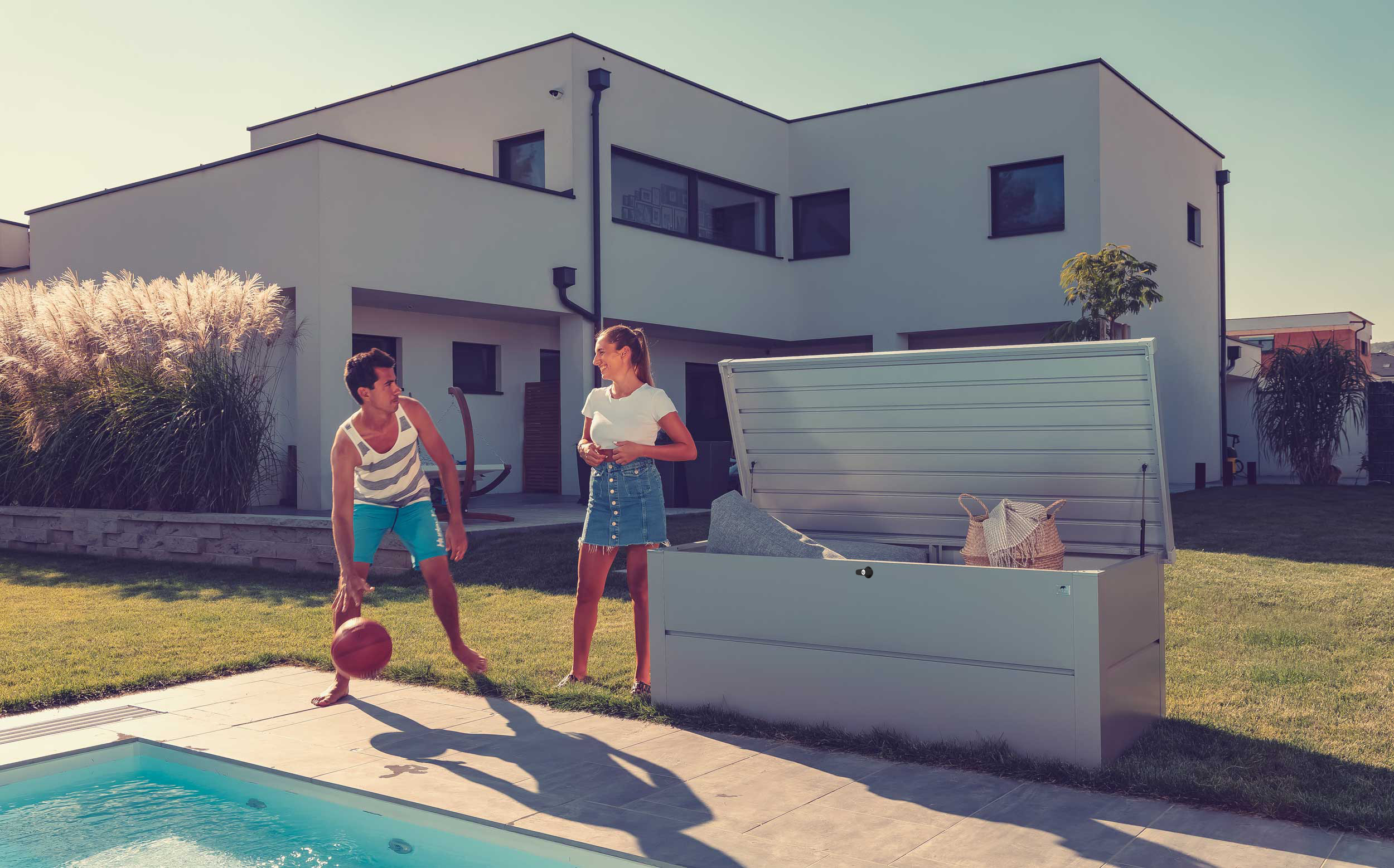gartenbox von guardi in silber vor modernem haus mit pool