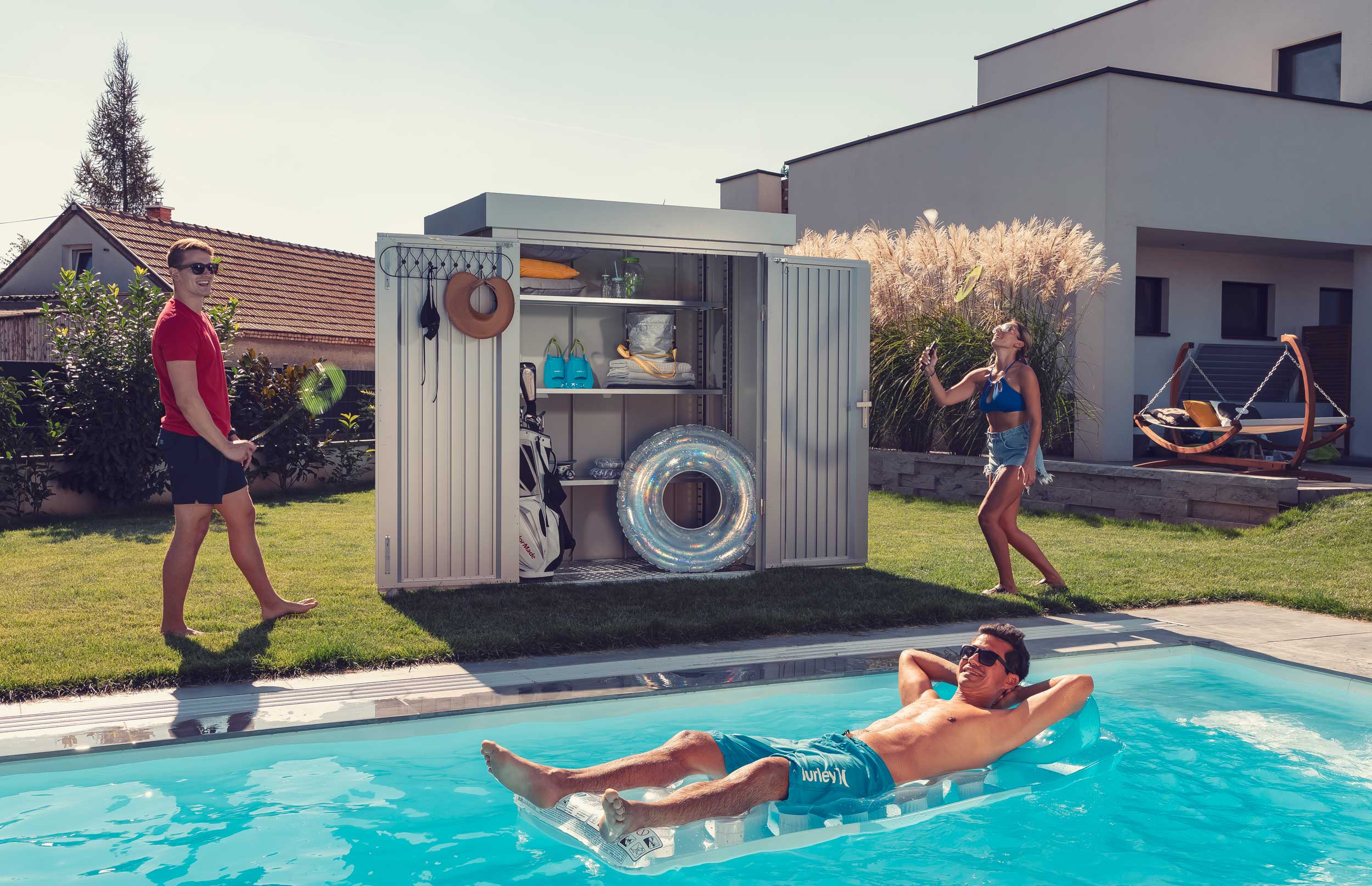 gartenhaus im garten neben modernem haus vor dem pool