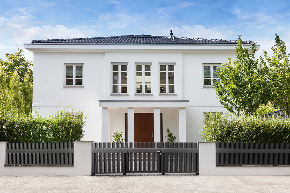 Moderner Aluminiumzaun von Guardi als Einfahrt mit passender Schiebetuer vor Villa