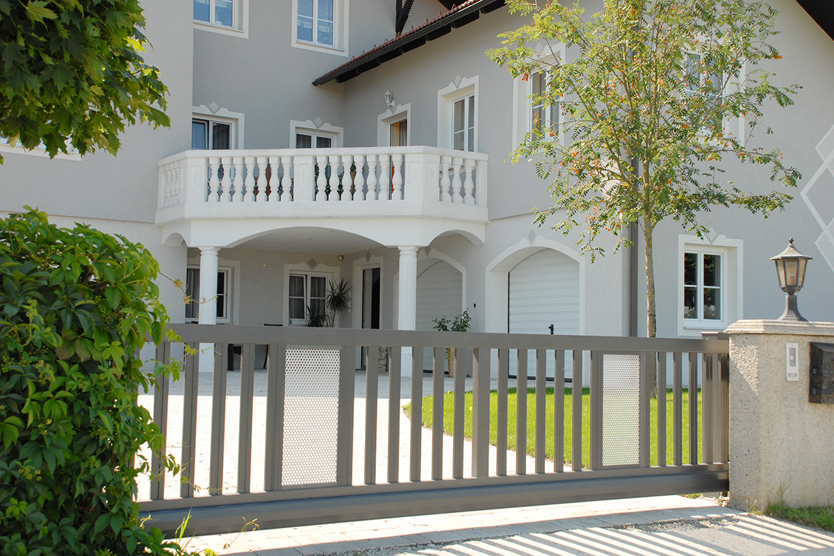 Fluegeltor elektrisch in Silber mit weissen Lochblech mit Villa