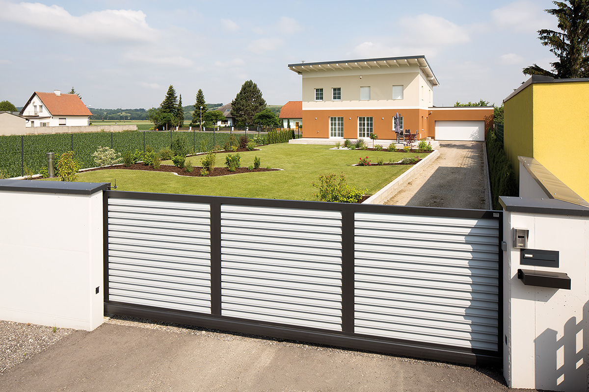 Schiebetuer elektrisch in zweifarbiger Optik mit grossem Garten und Haus