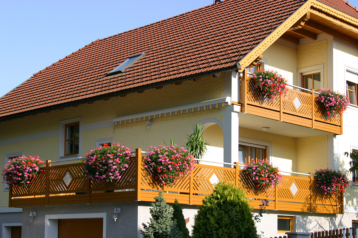 Balkon mit geometrischem Muster am Mehrfamilienhaus ohne blickdichte Ausführung in Holzfarbe