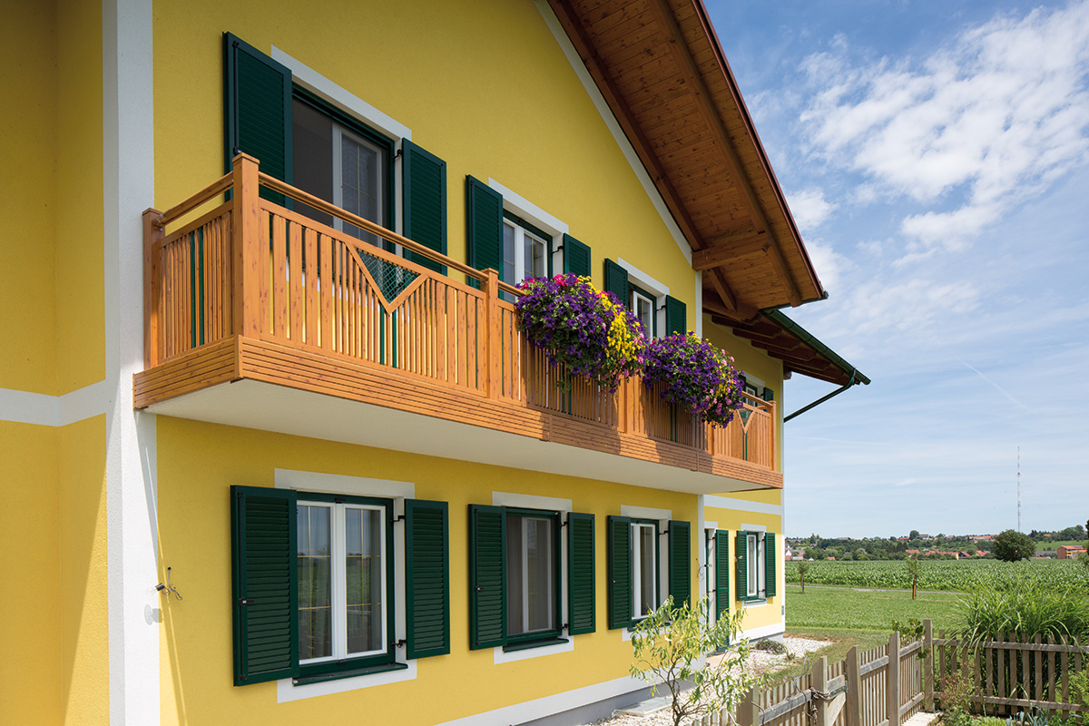 balkon von guardi an gelbem haus mit integrierten blumenkisten im selben design