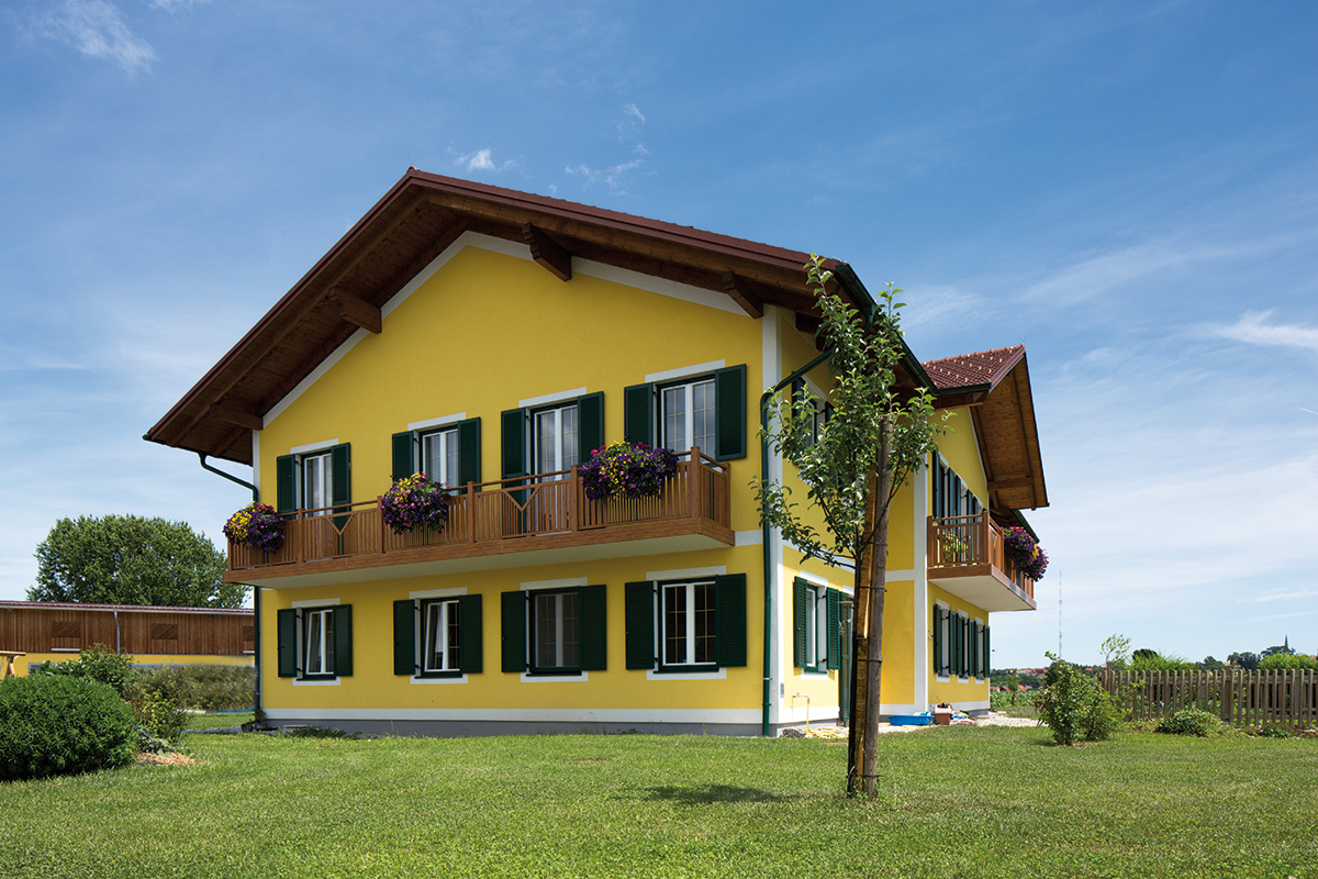 guardi balkon an gelbem haus mitten in der natur