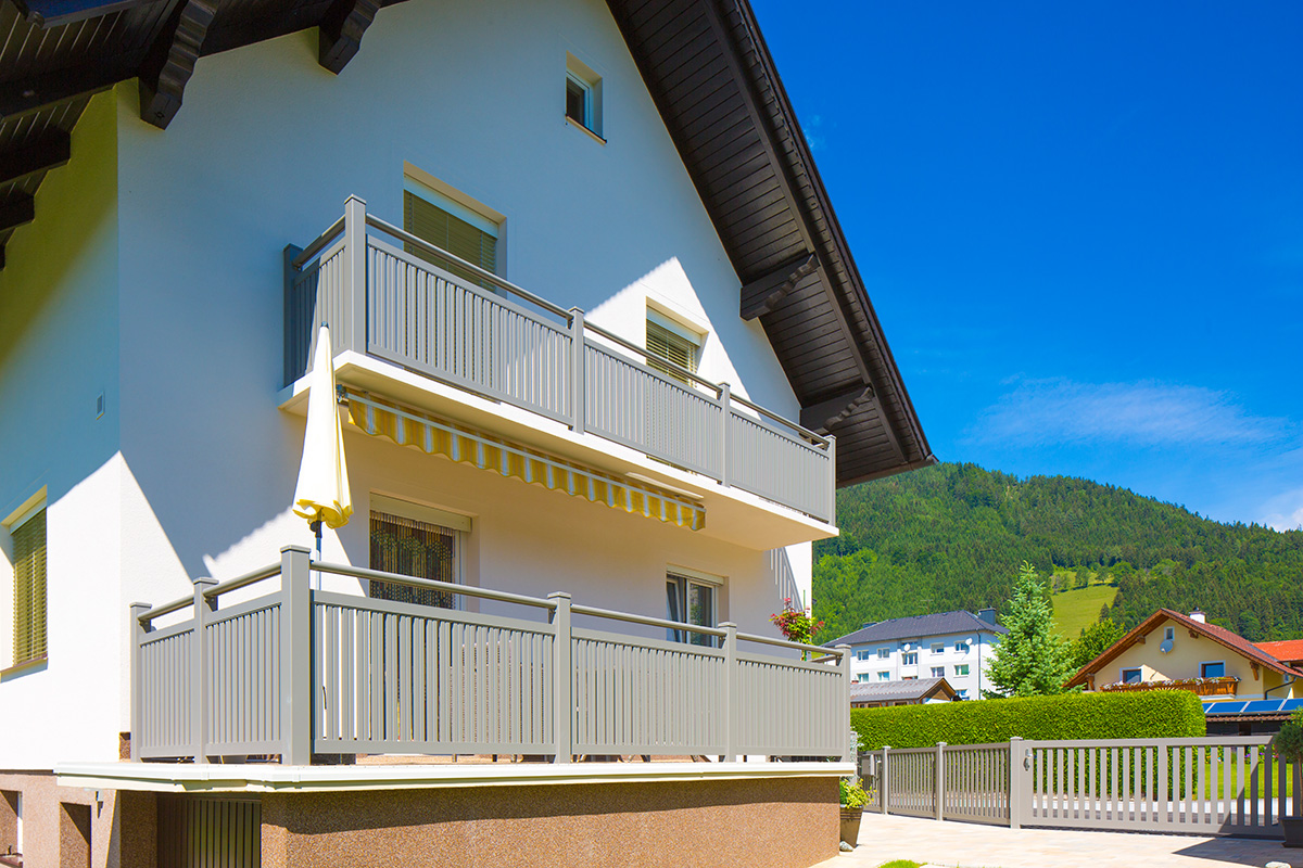 mehrere weisse balkongelaender in einem design passend zum weissen wohnhaus