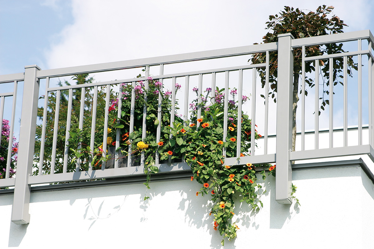 balkongelaender mit vielen blumen und topfpflanzen
