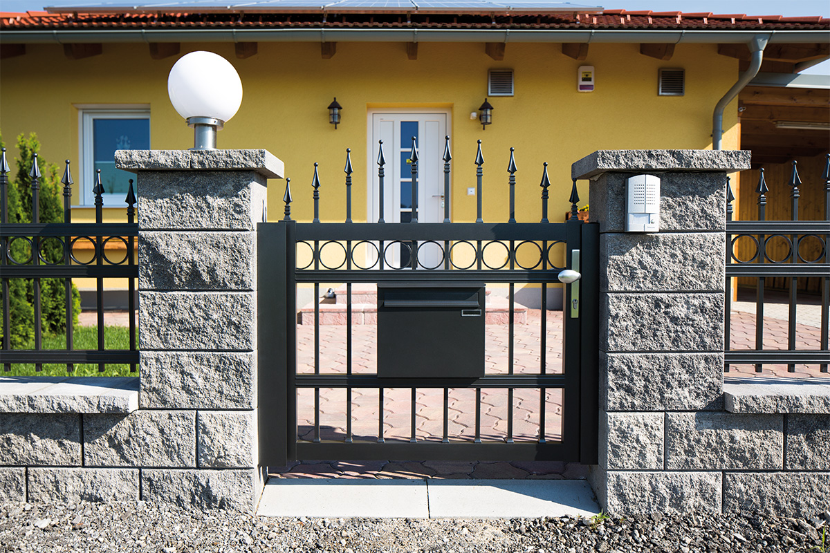 briefkasten mit gelbem haus im hintergrund