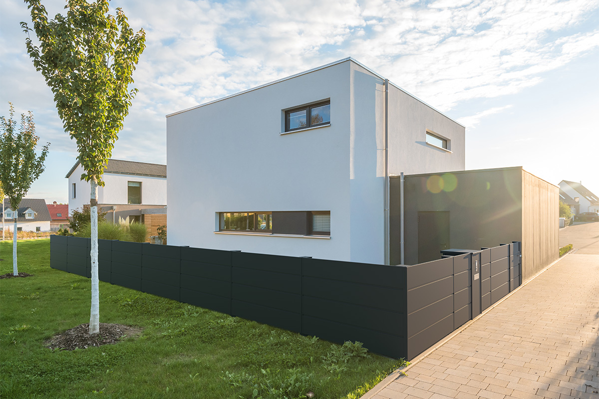 guardi sichtschutzzaun vor modernem weissen haus mit garten