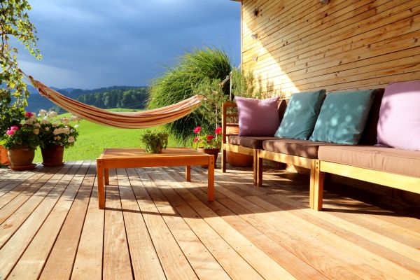Eine Terrasse mit Terrassendielen aus Aluminium, einer Hängematte und einer Gartenlounge